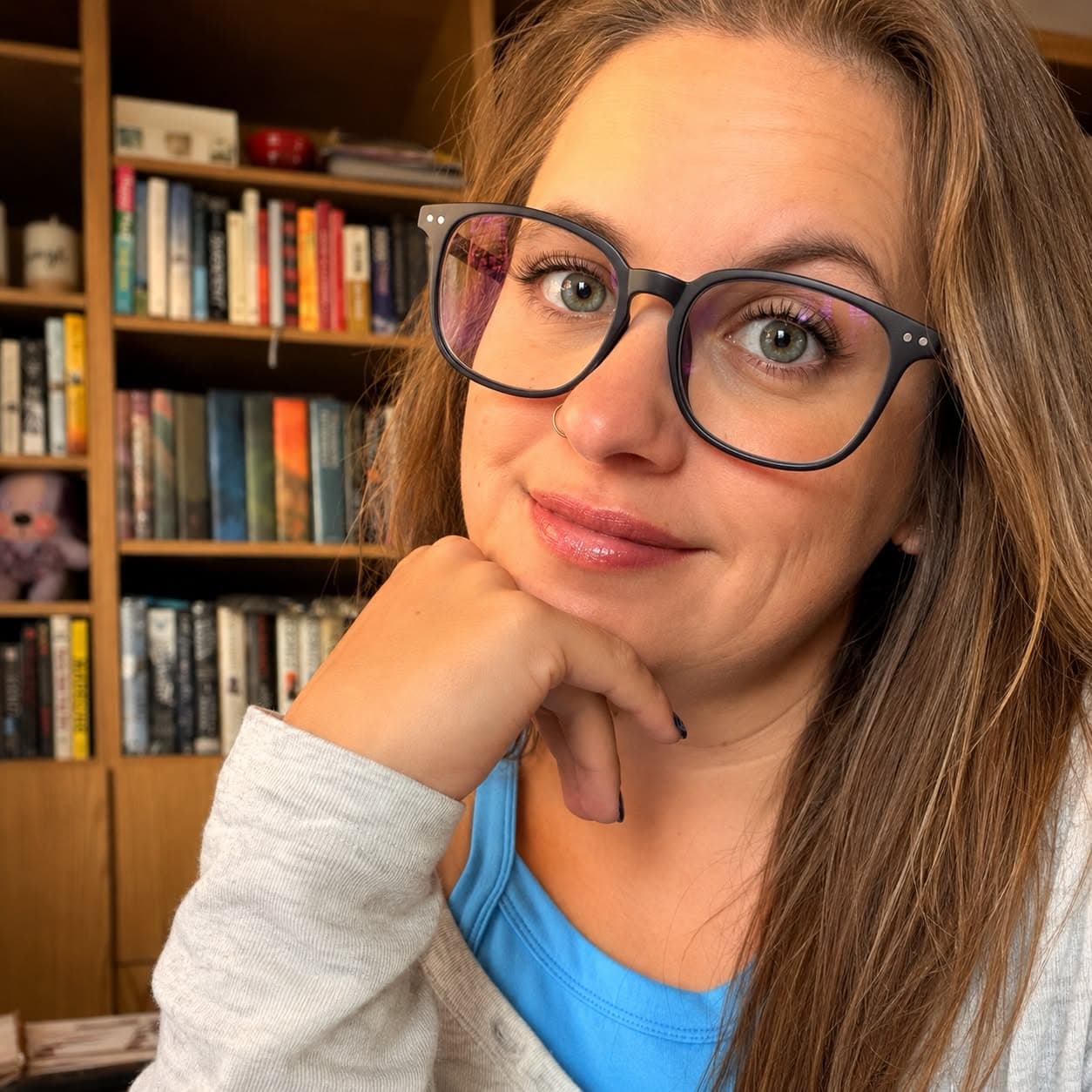 Kerri Lynn in glasses in front of a bookshelf